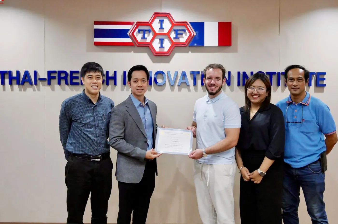 Enzo receiving his certificate of completion with the TFII team